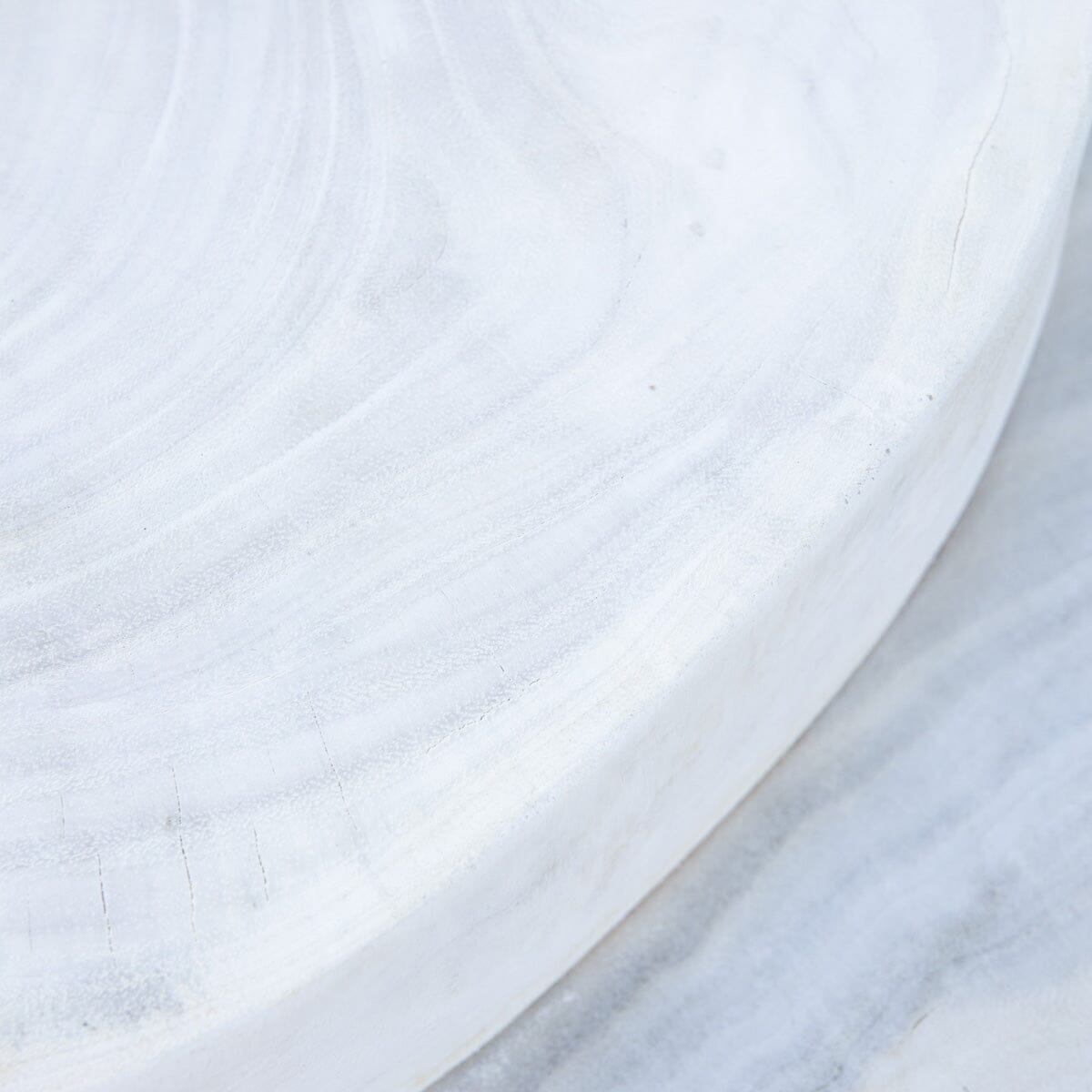 A beige, round, pancakes-layered coffee table made of reclaimed wood with a smooth finish.