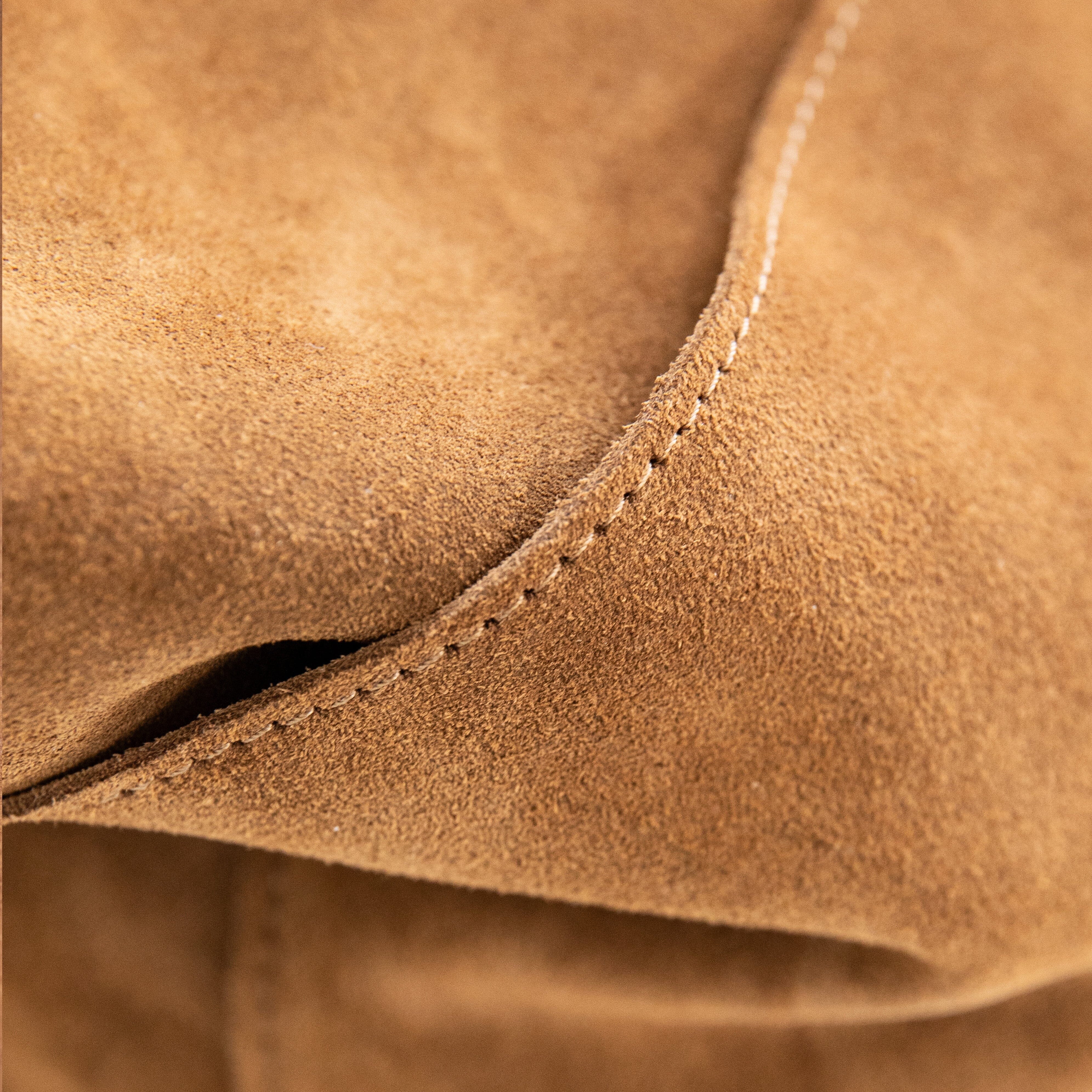 A brown suede crossbody bag with a shoulder strap, displayed against a white background.