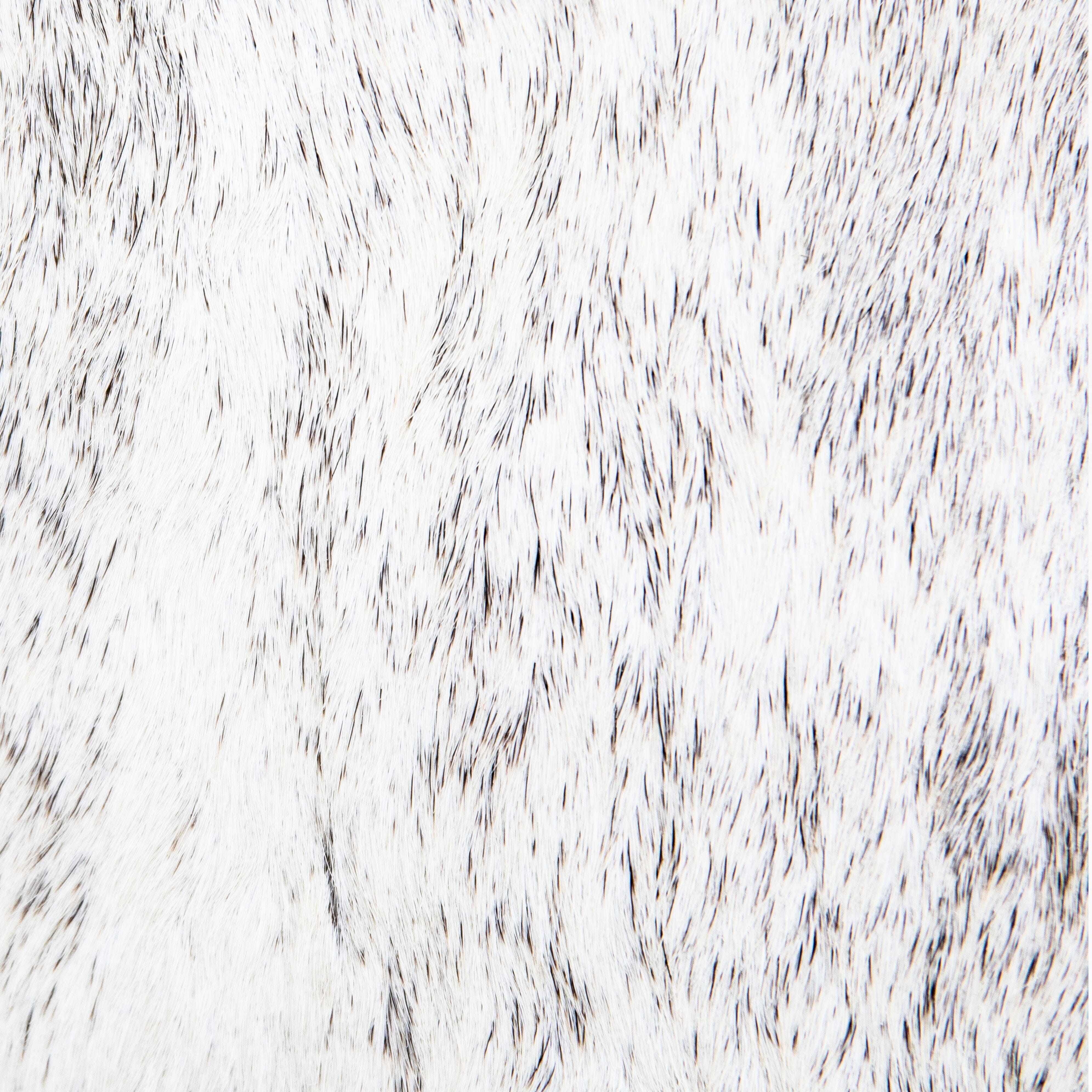 A white and beige crossbody shoulder bag made of hair-on-hide leather, featuring a brass clasp and a black shoulder strap.